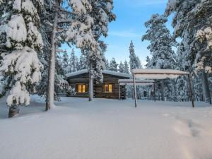 een blokhut in de sneeuw met een tuinhuisje bij Holiday Home Lumiankelo by Interhome in Sirkka