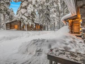une pile de neige à côté d'une cabane en rondins dans l'établissement Holiday Home Lumiankelo by Interhome, à Sirkka