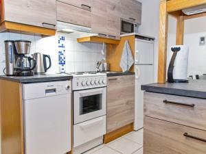 een keuken met een fornuis en een witte oven bij Holiday Home Alppitalo sinitähti 9 apt 1 by Interhome in Tahkovuori