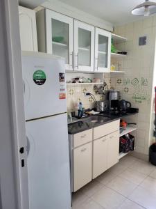 uma cozinha com armários brancos e um frigorífico branco em Oasis Lodging em Buenos Aires