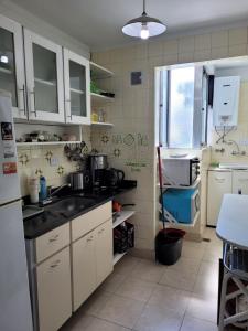 een keuken met een wastafel en een koelkast bij Oasis Lodging in Buenos Aires