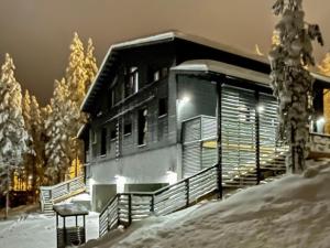 a house in the snow at night at Holiday Home Villa arcus a by Interhome in Pelkosenniemi