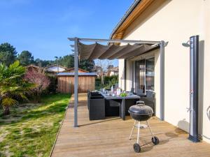 een barbecue op een terras met een patio bij Holiday Home Lamanchs by Interhome in Mimizan