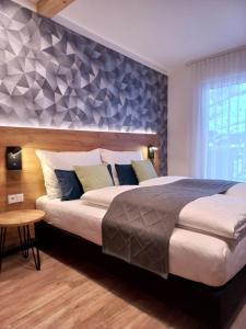 a bedroom with a large bed with a blue accent wall at Laudach INN in Vorchdorf