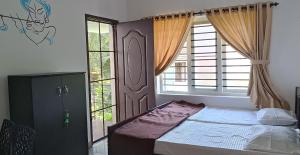 a bedroom with a bed and a large window at PRAKRITI HOMESTAY Fortkochi Air Conditioned Rooms in Cochin