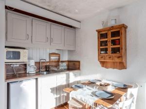 kuchnia z białymi szafkami i drewnianym stołem w obiekcie Studio La Christaz-7 by Interhome w mieście Saint-Gervais-les-Bains