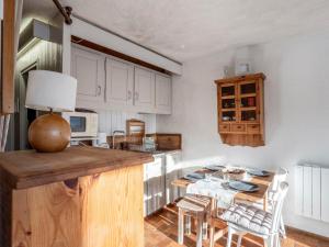 kuchnia z białymi szafkami i stołem z krzesłami w obiekcie Studio La Christaz-7 by Interhome w mieście Saint-Gervais-les-Bains