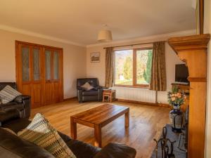 a living room with a couch and a table at Holiday Home Ceilidhtail Cottage by Interhome in Drumnadrochit