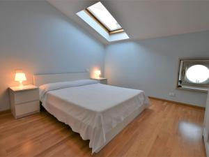 - une chambre avec un lit blanc et une lucarne dans l'établissement Apartment Duomo Mansarda by Interhome, à Iseo