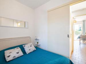 a bedroom with a bed with blue sheets and a mirror at Apartment Les Jardins de la Nartelle Beach by Interhome in Sainte-Maxime