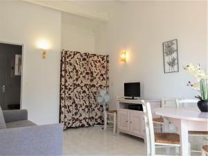 a living room with a table and a tv at Apartment Les Hauts des Issambres-8 by Interhome in La Garonnette-Plage