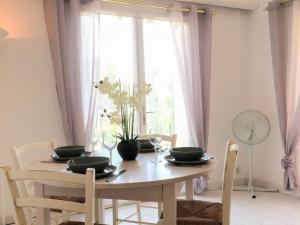a dining room table and chairs with a window at Apartment Les Hauts des Issambres-8 by Interhome in La Garonnette-Plage