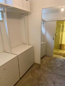 Zimmer mit weißen Schränken und einem Spiegel in der Unterkunft Ferienwohnung in Lay in Koblenz