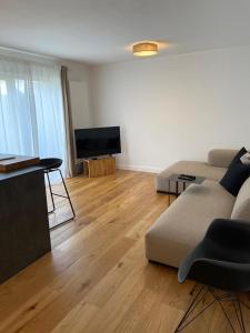 ein Wohnzimmer mit einem Sofa und einem Flachbild-TV in der Unterkunft Ferienwohnung in Lay in Koblenz