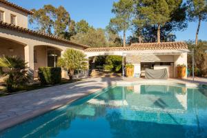 a swimming pool in front of a house at Appartement - Clos Saint Jean in Roquebrune-sur-Argens