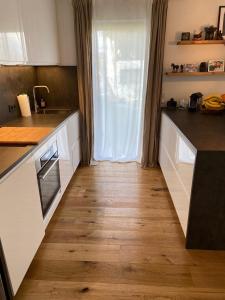 eine Küche mit weißen Schränken und Holzböden in der Unterkunft Ferienwohnung in Lay in Koblenz