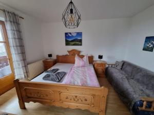 ein Schlafzimmer mit einem Holzbett und einem Sofa in der Unterkunft Urlaub am Bauernhof bei Familie Steinbrecher in Bad Mitterndorf