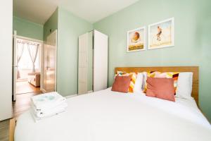 1 dormitorio con 1 cama blanca grande con almohadas coloridas en ［FITZROVIA-COVENT GARDEN］CENTRAL LONDON APARTMENT en Londres