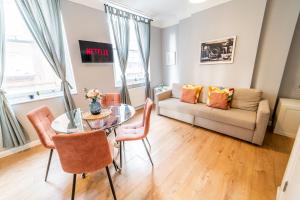 倫敦的住宿－［FITZROVIA-COVENT GARDEN］CENTRAL LONDON APARTMENT，客厅配有桌椅和沙发