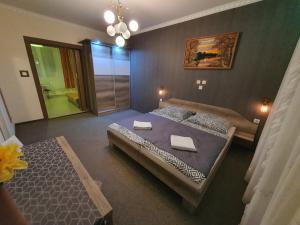 a bedroom with two beds and a large window at Szlavi Apartman in Baja