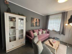 ein Wohnzimmer mit einem rosa Sofa und einem Tisch in der Unterkunft Ferienwohnung LePetit in Steina