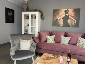 ein Wohnzimmer mit einem lila Sofa und einem Stuhl in der Unterkunft Ferienwohnung LePetit in Steina