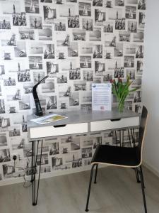 een bureau met een stoel voor een muur met foto's bij Austernfischer H-6-1 in Heiligenhafen