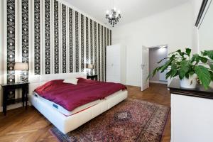 een slaapkamer met een groot bed en een tapijt bij Apartamenty Gołębia 3 in Krakau