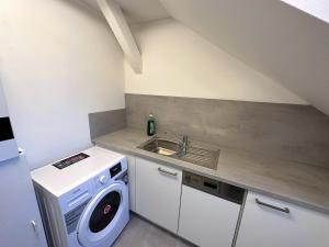 a small kitchen with a washing machine and a sink at Gemütliche, charmante Ferienwohnung Nähe Zentrum in Plauen