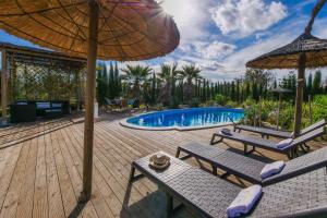 un patio con due sedie e un ombrellone e una piscina di Melongos a Inca
