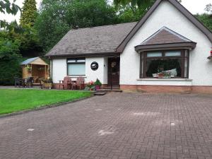 uma casa com uma entrada de tijolos em frente em Torrent Cottage em Coalisland