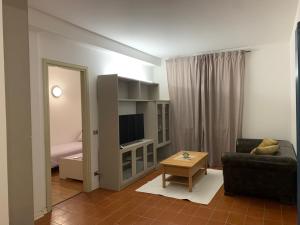 un soggiorno con divano e TV di Apartment Villa valmarana De Toni a Creazzo