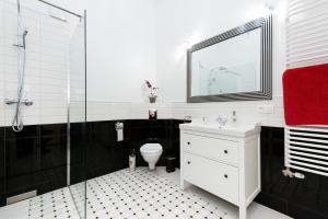 a bathroom with a toilet and a glass shower at Apartamenty Gołębia 3 in Krakow