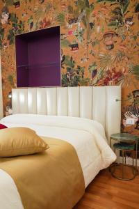 1 dormitorio con cama grande y papel pintado con motivos florales en Rosetta Burger Queen en Cagliari