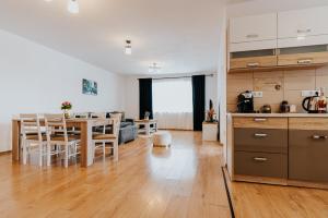 eine Küche und ein Wohnzimmer mit einem Tisch und Stühlen in der Unterkunft Lotus Apartman II in Odorheiu Secuiesc