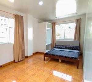 1 dormitorio con 1 cama y 2 ventanas en Beautiful 3br townhouse with garden and bonfire, en Baguio