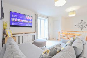 a living room with a couch and a flat screen tv at Broad Leaze 2 in Bristol