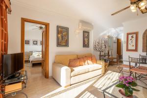 a living room with a couch and a television at Alto Rey Torrox Beach in Torrox Costa