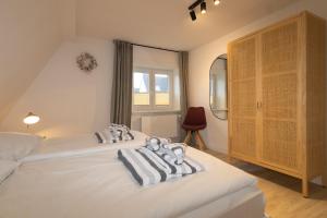 una camera da letto con due letti con asciugamani sopra di Kalle Blomquist a Hörnum