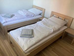dos camas con un libro encima de ellas en Apartament na Słonecznej, en Łączany