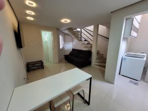 a living room with a black couch and a stairs at Excelente Casa Duplex em Tramandaí in Tramandaí +27 photos
