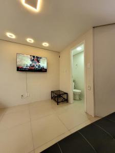 a living room with a television on the wall at Excelente Casa Duplex em Tramandaí in Tramandaí