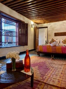 a room with two beds and a bottle on a table at Dar Attajalli in Fez