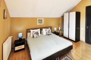 a bedroom with a bed with two lamps and a white cabinet at Flamingo Hotel in Tbilisi City