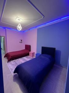 1 dormitorio con 1 cama y 1 sofá con luces azules en Luxury Apartment in Elbasan, en Elbasan