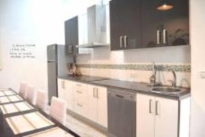 a kitchen with white cabinets and a sink and counters at APARTAMENTO VEEDOR 19 DÍAS Y MUCHAS NOCHES in Cádiz