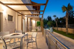 eine Terrasse mit einem weißen Tisch und Stühlen darauf in der Unterkunft Ariadni Apartments in Karteros