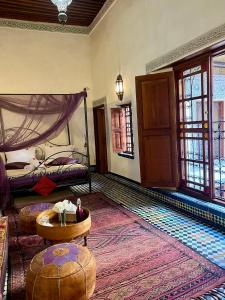 Habitación con 1 dormitorio con 1 cama y 1 mesa. en Dar Attajalli en Fez