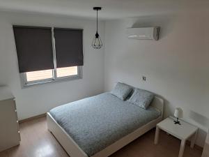 een witte slaapkamer met een bed en 2 ramen bij Modern Suite, XL balcony, parking in Nicosia