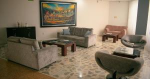 a living room with couches and chairs and a painting at Hotel Ruittoque D Prada in Bucaramanga